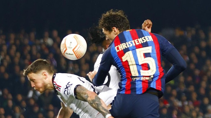 Barcelona's Andreas Christensen, right, heads the ball past Manchester United's Wout Weghorst during the Europa League playoff first leg soccer match between Barcelona and Manchester United at the Camp Nou stadium in Barcelona, Spain, Thursday, Feb. 16, 2023. (AP Photo/Joan Monfort)