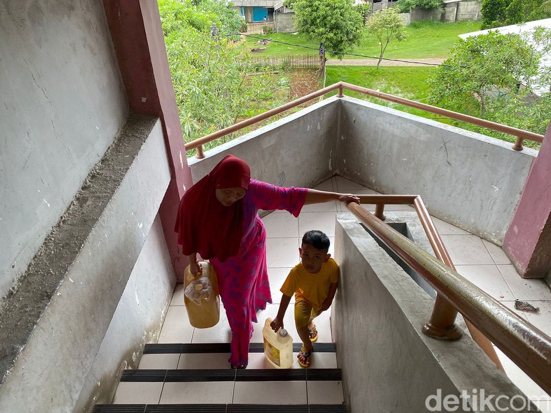 Muryati (46) dan putranya yang masih kecil mengangkut air dari lantai dasar sampai lantai 5 Rusun Marunda. 17 Februari 2023. (Devi Puspitasari/detikcom)