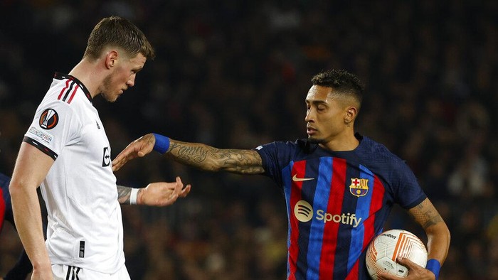 Barcelonas Raphinha, right, scuffles with Manchester Uniteds Wout Weghorst during the Europa League playoff first leg soccer match between Barcelona and Manchester United at the Camp Nou stadium in Barcelona, Spain, Thursday, Feb. 16, 2023. (AP Photo/Joan Monfort)