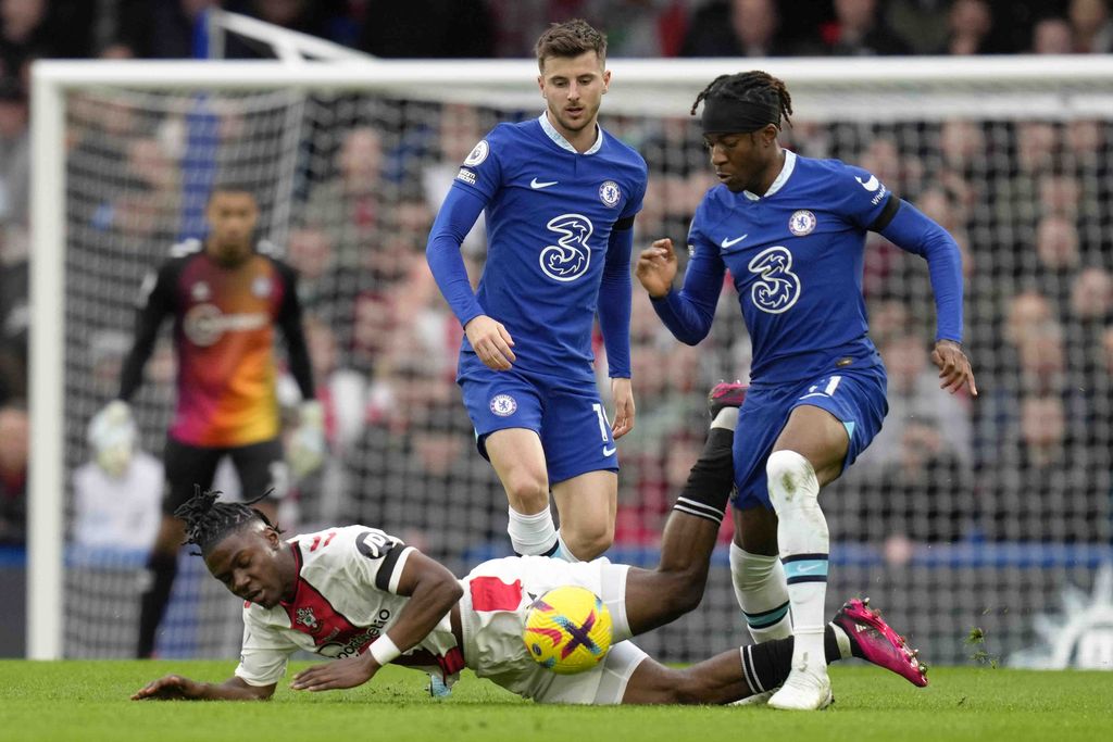 Southampton's Romeo Lavia, bottom, is challenged by Chelsea's Noni Madueke, right, during the English Premier League soccer match between Chelsea and Southampton at the Stamford Bridge stadium in London, Saturday, Feb. 18, 2023. (AP Photo/Kirsty Wigglesworth)