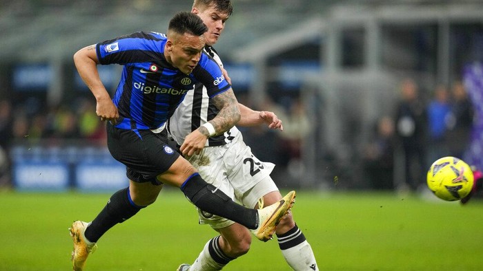 Inter Milans Lautaro Martinez, left, scores his sides third goal during the Serie A soccer match between Inter Milan and Udinese at the San Siro stadium, in Milan, Italy, Saturday, Feb. 18, 2023. (AP Photo/Antonio Calanni)