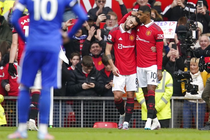 Manchester Uniteds Marcus Rashford, right, celebrates after scoring his sides opening goal with Manchester Uniteds Bruno Fernandes during the English Premier League soccer match between Manchester United and Leicester City at the Stamford Bridge stadium in Manchester, England, Sunday, Feb. 19, 2023. (AP Photo/Dave Thompson)