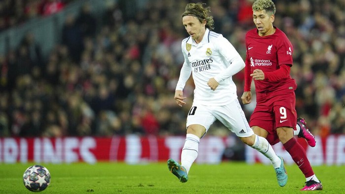 Real Madrids Luka Modric, left, passes the ball past Liverpools Roberto Firmino during the Champions League, round of 16, first leg soccer match between Liverpool and Real Madrid at the Anfield stadium in Liverpool, England, Tuesday, Feb. 21, 2023. (AP Photo/Jon Super)