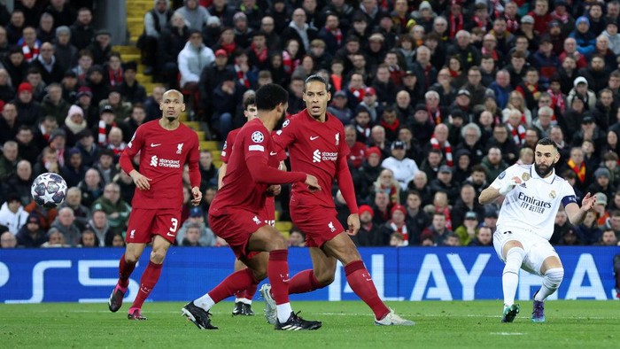 LIVERPOOL, ENGLAND - FEBRUARY 21: Karim Benzema of Real Madrid scores the teams fourth goal as Virgil van Dijk and Joe Gomez of Liverpool look on during the UEFA Champions League round of 16 leg one match between Liverpool FC and Real Madrid at Anfield on February 21, 2023 in Liverpool, England. (Photo by Alex Livesey - UEFA/UEFA via Getty Images)