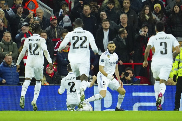 Real Madrids Karim Benzema, second right, celebrates after scoring his sides fourth goal during the Champions League, round of 16, first leg soccer match between Liverpool and Real Madrid at the Anfield stadium in Liverpool, England, Tuesday, Feb. 21, 2023. (AP Photo/Jon Super)