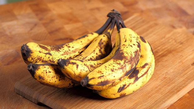 Bunch of overripe bananas on a wooden background