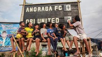 Anak-anak melihat papan skor berganti secara manual usai pemain memasukkan gol. Liga Tarkam Bina Jaya Cup telah berlangsung rutin setiap tahun.