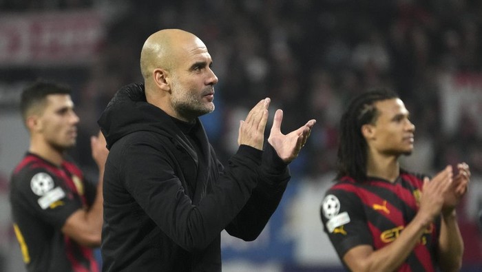 Manchester Citys head coach Pep Guardiola applauds the crowd after the Champions League round of 16 first leg soccer match between RB Leipzig and Manchester City in Leipzig, Germany, Wednesday, Feb 22, 2023. The match ended in a 1-1 draw. (AP Photo/Michael Sohn)