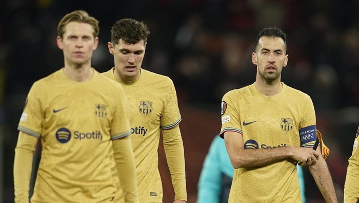 Barcelonas Frenkie de Jong, left, Barcelonas Andreas Christensen, centre, and Barcelonas Sergio Busquets walk off the field at the end of the Europa League playoff second leg soccer match between Manchester United and Barcelona at Old Trafford stadium in Manchester, England, Thursday, Feb. 23, 2023. Manchester United won 2-1. (AP Photo/Dave Thompson)