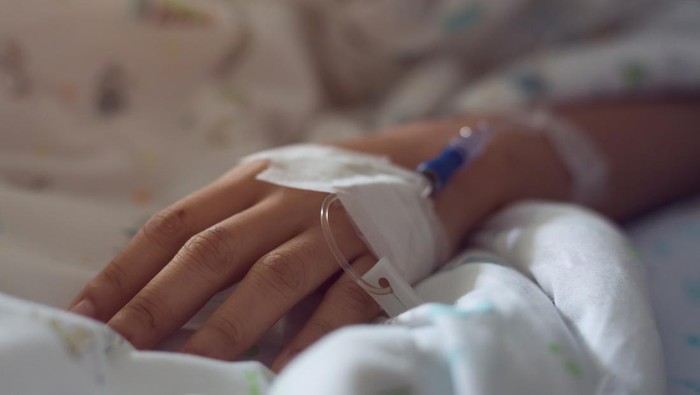 medical infusion iv drip saline solution in hand patient illness unwell