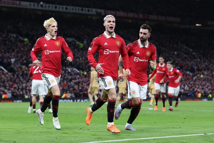 MANCHESTER, ENGLAND - FEBRUARY 23: Antony of Manchester United celebrates with teammates Bruno Fernandes and Alejandro Garnacho after scoring the teams second goal during the UEFA Europa League knockout round play-off leg two match between Manchester United and FC Barcelona at Old Trafford on February 23, 2023 in Manchester, England. (Photo by Alex Livesey - UEFA/UEFA via Getty Images)