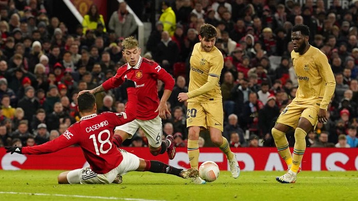 Momen Manchester United Singkirkan Barcelona dari Liga Europa Barcelona's Sergi Roberto, second right, attempts a shot at goal in front of Manchester United's Casemiro, left, and Manchester United's Lisandro Martinez during the Europa League playoff second leg soccer match between Manchester United and Barcelona at Old Trafford stadium in Manchester, England, Thursday, Feb. 23, 2023. (AP Photo/Dave Thompson)