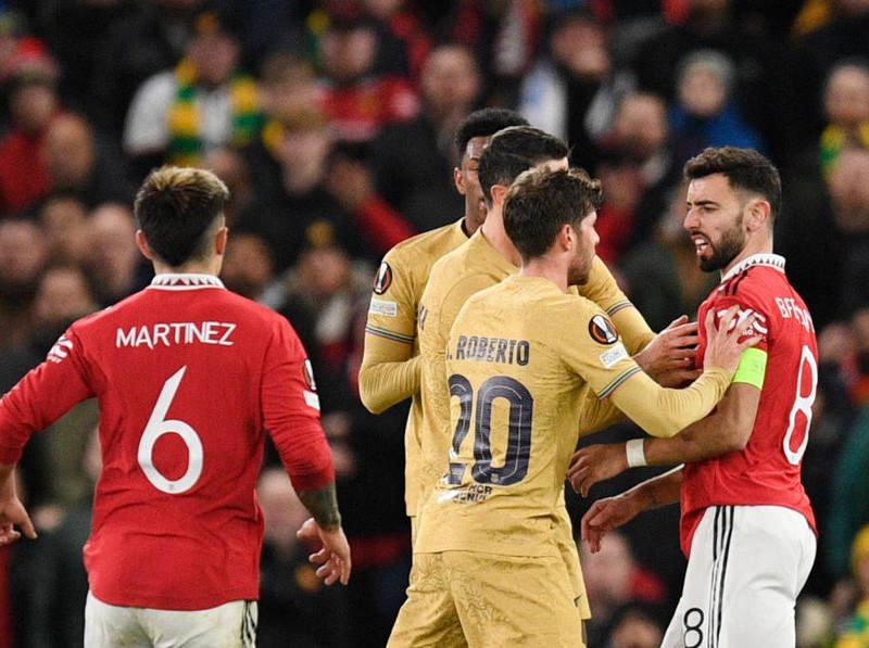 Barcelona's Spanish midfielder Sergi Roberto (2nd R) argues with Manchester United's Portuguese midfielder Bruno Fernandes (R) after he cleared the ball and touched Barcelona's Dutch midfielder Frenkie de Jong (unseen) during the UEFA Europa league knockout round play-off second leg football match between Manchester United and FC Barcelona at Old Trafford stadium in Manchester, north west England, on February 23, 2023. (Photo by Oli SCARFF / AFP) (Photo by OLI SCARFF/AFP via Getty Images)