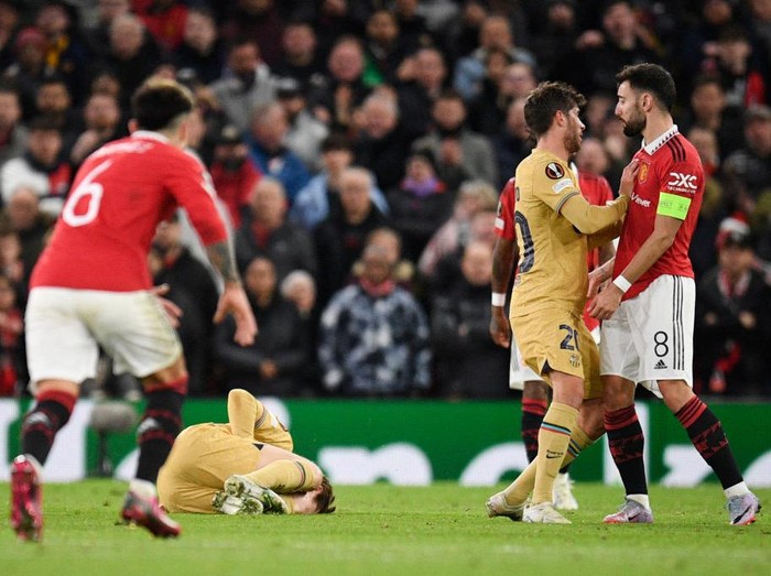 Ribut-ribut di Laga Manchester United Vs Barcelona Barcelona's Spanish midfielder Sergi Roberto (2nd R) argues with Manchester United's Portuguese midfielder Bruno Fernandes (R) after he cleared the ball and touched Barcelona's Dutch midfielder Frenkie de Jong (down) who reacts on the ground during the UEFA Europa league knockout round play-off second leg football match between Manchester United and FC Barcelona at Old Trafford stadium in Manchester, north west England, on February 23, 2023. (Photo by Oli SCARFF / AFP) (Photo by OLI SCARFF/AFP via Getty Images)