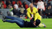 Bagaikan adegan di arena UFC, Marko Dmitrovic kemudian berhasil mengunci si penyusup lapangan. Foto: REUTERS/PIROSCHKA VAN DE WOUW