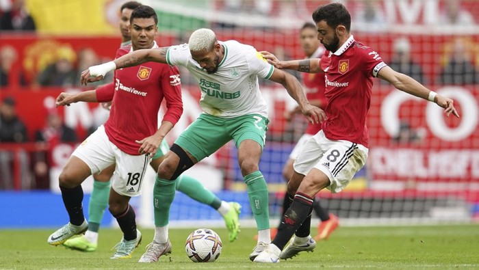 Newcastles Joelinton, centre, challenges for the ball with Manchester Uniteds Bruno Fernandes, right, and Manchester Uniteds Casemiro, left, during the English Premier League soccer match between Manchester United and Newcastle at Old Trafford stadium in Manchester, England, Sunday, Oct. 16, 2022. (AP Photo/Dave Thompson)