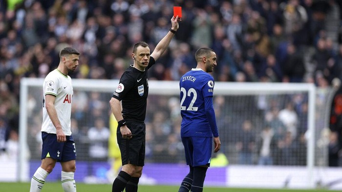 Referee Stuart Attwell shows the red card to Chelseas Hakim Ziyech, right, during the English Premier League soccer match between Tottenham Hotspur and Chelsea at Tottenham Hotspur Stadium in London, Sunday, Feb. 26, 2023.(AP Photo/Ian Walton)