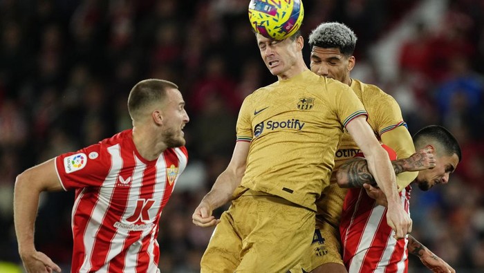 Barcelonas Robert Lewandowski, top, heads the ball during the Spanish La Liga soccer match between Almeria and Barcelona at the Juegos Mediterraneos stadium in Almeria, Spain, Sunday, Feb. 26, 2023. Almeria won 1-0. (AP Photo/Jose Breton)