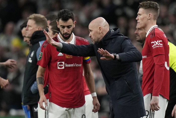 Manchester Uniteds head coach Erik ten Hag, centre, talks to Bruno Fernandes, left, during the English League Cup final soccer match between Manchester United and Newcastle United at Wembley Stadium in London, Sunday, Feb. 26, 2023. (AP Photo/Alastair Grant)