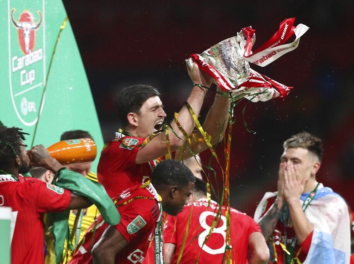 Manchester United's Harry Maguire holds the trophy aloft as he celebrates with teammates after winning the English League Cup final soccer match between Manchester United and Newcastle United at Wembley Stadium in London, Sunday, Feb. 26, 2023. Manchester United won 2-0. (AP Photo/Scott Heppell)