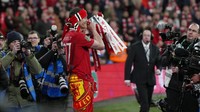 Weghorst, yang dipinjam MU pada bulan Januari lalu, menjadi salah satu yang amat riang-gembira pamer trofi. Foto: AP/Alastair Grant
