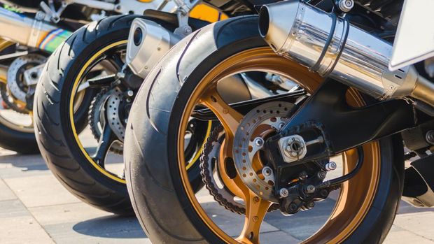 row of rear wheels of sports bikes in competition close up