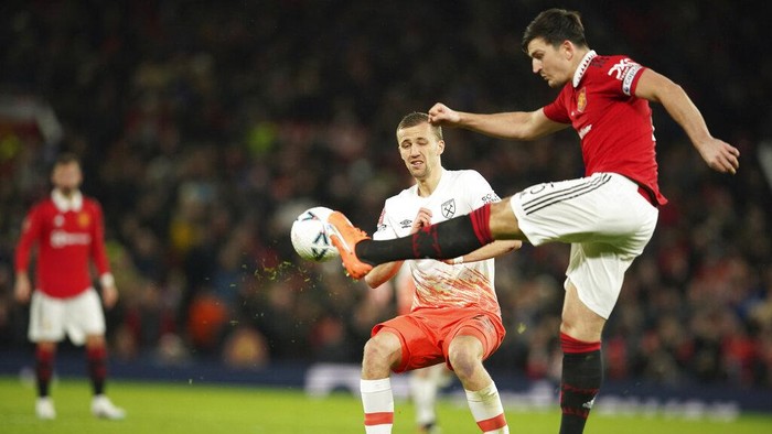 Manchester Uniteds Harry Maguire, right, kicks the ball ahead of West Hams Tomas Soucek during the English FA Cup fifth round soccer match between Manchester United and West Ham at Old Trafford stadium in Manchester, England, Wednesday, March 1, 2023. (AP Photo/Dave Thompson)
