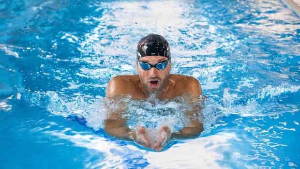 Sports male swimmer swimming in the pool, breaststroke swimming. Front view, techniques swimming.