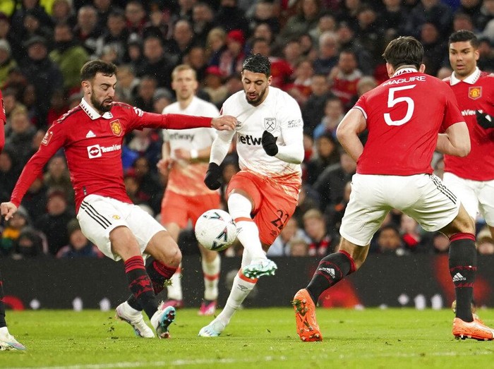 MU Menang Dramatis Atas West Ham, Melaju ke Perempatfinal Piala FA West Ham's Said Benrahma, centre, scores his side's opening goal during the English FA Cup fifth round soccer match between Manchester United and West Ham at Old Trafford stadium in Manchester, England, Wednesday, March 1, 2023. (AP Photo/Dave Thompson)