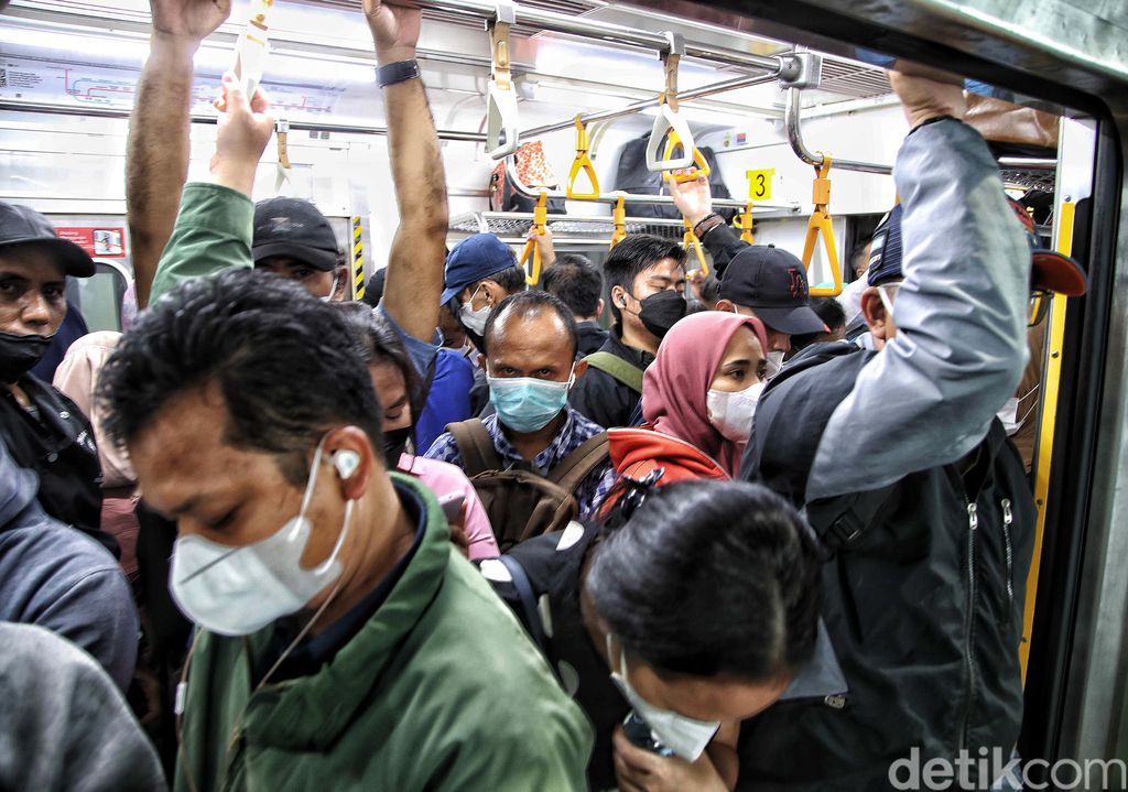 Ratusan penumpang berusaha masuk ke dalam transportasi umum KRL di Stasiun Manggarai, Rabu (22/2/2023).