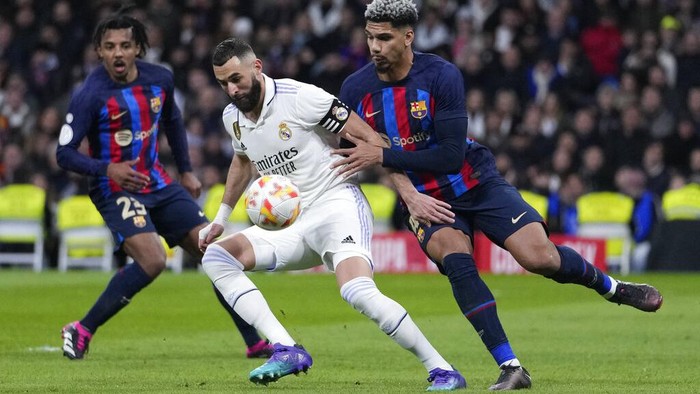 Real Madrids Karim Benzema, centre, controls the ball as he is challenged by Barcelonas Ronald Araujo, right, and Barcelonas Jules Kounde during the Spanish Copa del Rey semi final, first leg soccer match between Real Madrid and Barcelona at Santiago Bernabeu stadium in Madrid, Spain, Thursday, March 2, 2023. (AP Photo/Bernat Armangue)