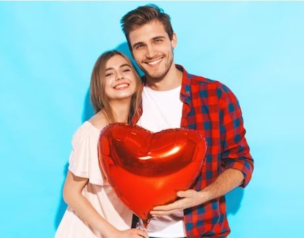 Couple sedang memegang balon bentuk hati warna merah
