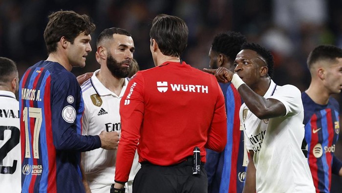 Soccer Football - Copa del Rey - Semi Final - First Leg - Real Madrid v FC Barcelona - Santiago Bernabeu, Madrid, Spain - March 2, 2023 Referee Jose Luis Munuera Montero talks to Real Madrids Karim Benzema and Vinicius Junior before awarding the first goal to FC Barcelona after a VAR review REUTERS/Juan Medina