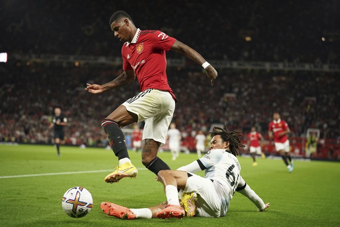 Manchester Uniteds Marcus Rashford, left, challenges for the ball with Liverpools Trent Alexander-Arnold during the English Premier League soccer match between Manchester United and Liverpool at Old Trafford stadium, in Manchester, England, Monday, Aug 22, 2022. (AP Photo/Dave Thompson)