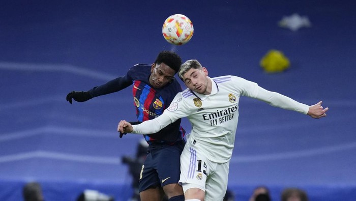 Barcelonas Alejandro Balde, left, duels for the ball with Real Madrids Federico Valverde during the Spanish Copa del Rey semi final, first leg soccer match between Real Madrid and Barcelona at Santiago Bernabeu stadium in Madrid, Spain, Thursday, March 2, 2023. (AP Photo/Manu Fernandez)
