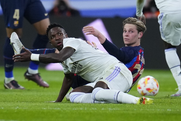 Real Madrids Vinicius Junior, front, challenges with Barcelonas Frenkie de Jong during the Spanish Copa del Rey semi final, first leg soccer match between Real Madrid and Barcelona at Santiago Bernabeu stadium in Madrid, Spain, Thursday, March 2, 2023. (AP Photo/Manu Fernandez)
