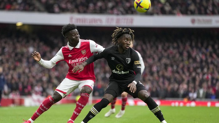 Arsenals Bukayo Saka, left, and Bournemouths Jordan Zemura vie for the ball during the English Premier League soccer match between Arsenal and Bournemouth at the Emirates stadium in London, England, Saturday, March 4, 2023. (AP Photo/Kin Cheung)