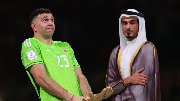 LUSAIL CITY, QATAR - DECEMBER 18: H.E Sheikh Jassim Bin Hamad Al Thani looks on as Emiliano Martinez of Argentina gestures with the world cup trophy during the FIFA World Cup Qatar 2022 Final match between Argentina and France at Lusail Stadium on December 18, 2022 in Lusail City, Qatar. (Photo by Marc Atkins/Getty Images)