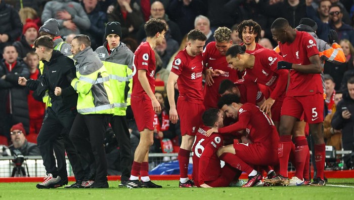 LIVERPOOL, ENGLAND - MARCH 05: A fan is lead away after running on the pitch after Liverpool scored a goal to make it 7-0 during the Premier League match between Liverpool FC and Manchester United at Anfield on March 5, 2023 in Liverpool, United Kingdom. (Photo by Robbie Jay Barratt - AMA/Getty Images)