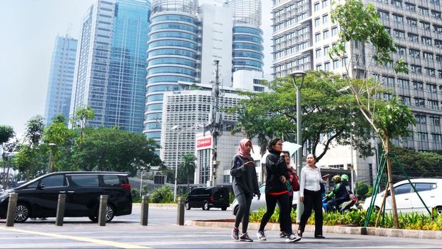 people walking on wide pedestrian along general sudirman street senayan , jakarta city Indonesia