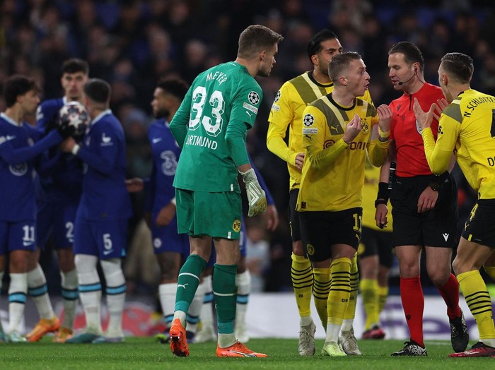 Dortmund players surround Referee Danny Makkelie after he deemed that Chelseas German midfielder Kai Havertz (2L) should re-take his penalty following a VAR review, during the UEFA Champions League round of 16 second-leg football match between Chelsea and Borrusia Dortmund at Stamford Bridge in London on March 7, 2023. (Photo by Adrian DENNIS / AFP) (Photo by ADRIAN DENNIS/AFP via Getty Images)