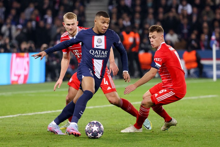PARIS, FRANCE - FEBRUARY 14: Kylian Mbappe of PSG between Matthijs de Ligt and Joshua Kimmich of Bayern Munich during the UEFA Champions League round of 16 leg one match between Paris Saint-Germain (PSG) and FC Bayern Muenchen (Bayern Munich, Bayern München) at Parc des Princes stadium on February 14, 2023 in Paris, France. (Photo by Jean Catuffe/Getty Images)
