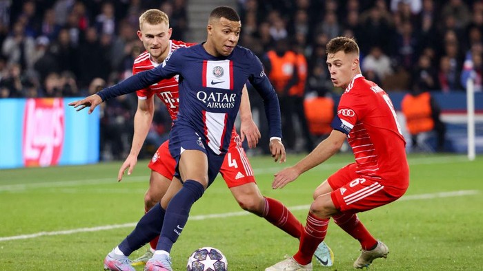 PARIS, FRANCE - FEBRUARY 14: Kylian Mbappe of PSG between Matthijs de Ligt and Joshua Kimmich of Bayern Munich during the UEFA Champions League round of 16 leg one match between Paris Saint-Germain (PSG) and FC Bayern Muenchen (Bayern Munich, Bayern München) at Parc des Princes stadium on February 14, 2023 in Paris, France. (Photo by Jean Catuffe/Getty Images)