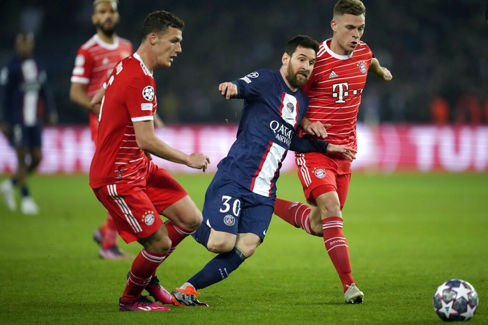PSGs Lionel Messi, center, duels for the ball with Bayerns Joshua Kimmich, right, and Bayerns Benjamin Pavard during the Champions League round of 16 first leg soccer match between Paris Saint Germain and Bayern Munich, at the Parc des Princes stadium, in Paris, France, Tuesday, Feb. 14, 2023. (AP Photo/Christophe Ena)