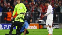 Petugas berompi ini adalah steward lapangan. Ia adalah salah satu yang sampai lebih dulu untuk meringkus si penyusup lapangan. Foto: REUTERS/KAI PFAFFENBACH