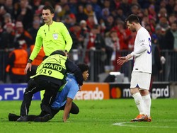 Petugas berompi ini adalah steward lapangan. Ia adalah salah satu yang sampai lebih dulu untuk meringkus si penyusup lapangan. Foto: REUTERS/KAI PFAFFENBACH