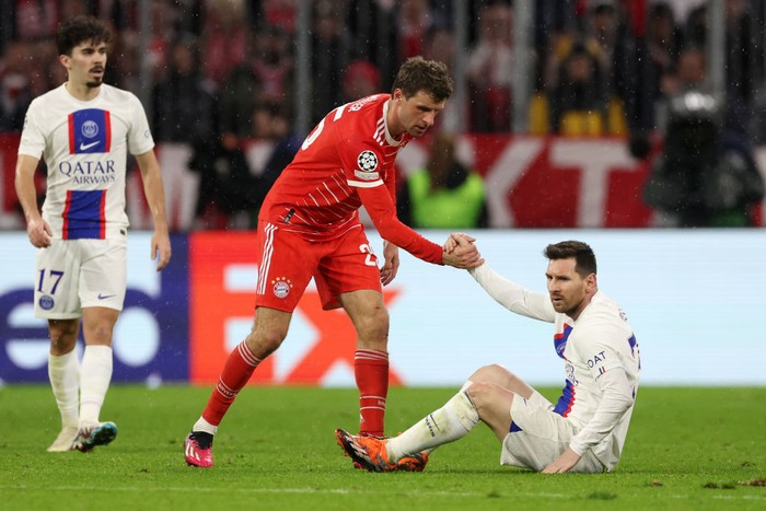 MUNICH, GERMANY - MARCH 08: Thomas Mueller of FC Bayern Munich helps up Lionel Messi of Paris Saint-Germain during the UEFA Champions League round of 16 leg two match between FC Bayern München and Paris Saint-Germain at Allianz Arena on March 08, 2023 in Munich, Germany. (Photo by Alexander Hassenstein/Getty Images)