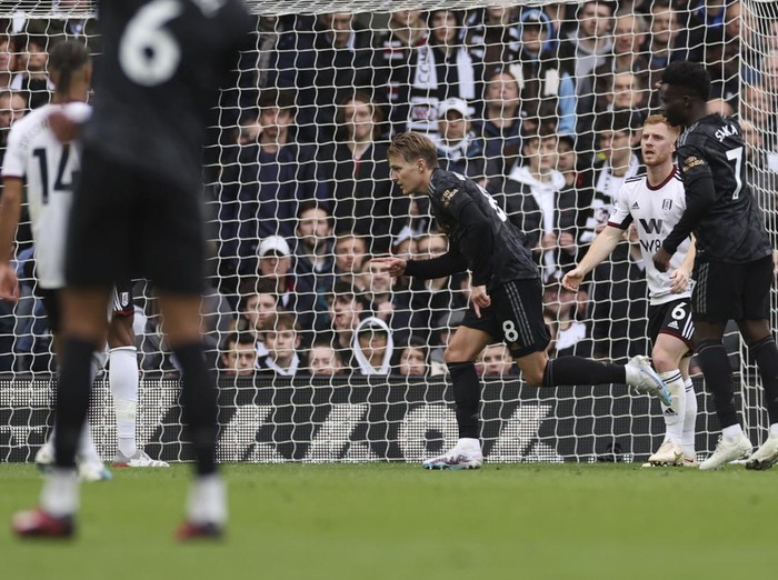 Arsenal's Martin Odegaard, center, celebrates after scoring his side's third goal during the English Premier League soccer match between Fulham and Arsenal at Craven Cottage stadium in London, Sunday, March 12, 2023. (AP Photo/Ian Walton)