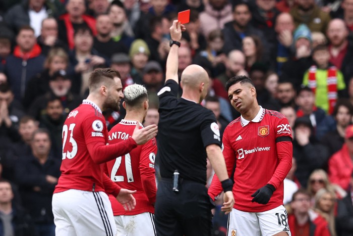 Manchester Uniteds Brazilian midfielder Casemiro (R) reacts after being shown a red card by English referee Anthony Taylor during the English Premier League football match between Manchester United and Southampton at Old Trafford in Manchester, north-west England, on March 12, 2023. (Photo by Darren Staples / AFP) / RESTRICTED TO EDITORIAL USE. No use with unauthorized audio, video, data, fixture lists, club/league logos or live services. Online in-match use limited to 120 images. An additional 40 images may be used in extra time. No video emulation. Social media in-match use limited to 120 images. An additional 40 images may be used in extra time. No use in betting publications, games or single club/league/player publications. /  (Photo by DARREN STAPLES/AFP via Getty Images)