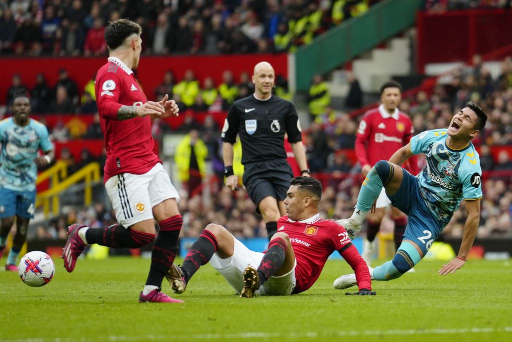 Manchester United's Casemiro, bottom centre, in action against Southampton's Carlos Alcaraz, right, during the English Premier League soccer match between Manchester United and Southampton at Old Trafford stadium in Manchester, England, Sunday, March 12, 2023. (AP Photo/Jon Super)